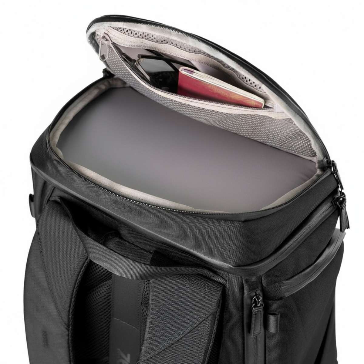 Lähikuva ylhäältä mustasta repusta, ylin lokero auki ja sisäpuolen järjestys näkyvissä.