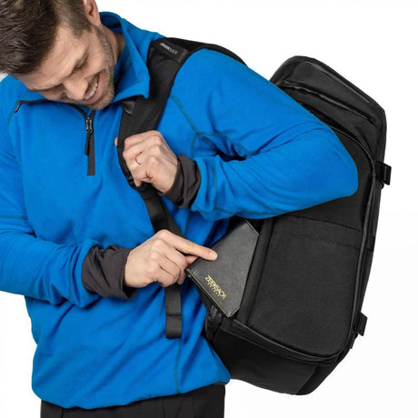 Mies laittaa passikotelon Zeeksack-repun sivutaskuun.