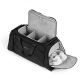 Musta duffelilaukku, jossa järjestetyt lokerot ja erillinen kenkälokero valkoisilla kengillä.