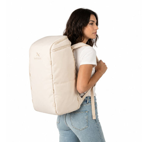 Nainen, jolla on selässään Zeeksack The Organizer 40L -reppu värissä Sand White