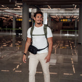 Zeeksack - Mies, jolla on The Underseat 15L selässään ja Crossbody Organizer vyötäröllään lentokentällä.