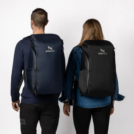 Mies ja nainen kantavat Zeeksack-reppuja selässään – musta ja sininen väri, unisex-malli.